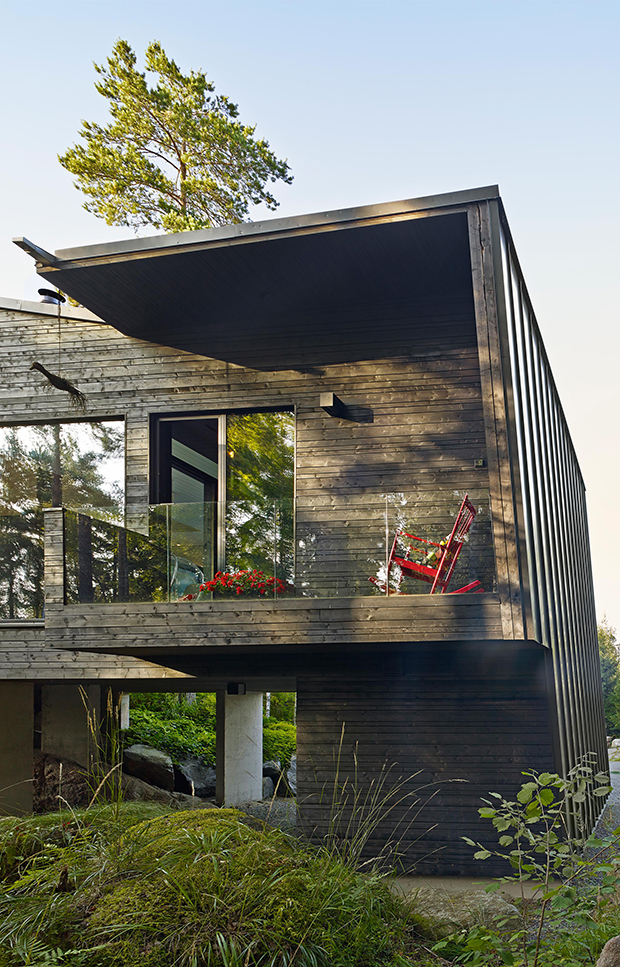 Les fac?ades, en panneaux de bois irre?guliers enduits de goudron, donnent a? la maison des allures de rocher noir multifacettes.