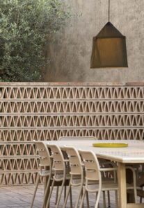 PMMT Arquitectura has recently completed work on its latest residential project in Girona, Spain - PIN8 House. Situated in the picturesque region of Baix Empordà, the design of the PIN8 HOUSE is thoughtfully crafted to harmonize with the urban fabric and heritage of its surrounding town. The design seamlessly integrates the unique qualities of the surrounding environment with the specific requirements of its occupants. This harmonious blend is evident in the careful selection of materials, the thoughtful construction system, the adaptable nature of the space, the efficient distribution, and the seamless connection between the outdoor and indoor areas. This architecturally striking standalone residence boasts a sleek rectangular floor plan and spans across two impressive levels. Its design philosophy revolves around achieving optimal permeability by incorporating expansive openings, double-height spaces, and thoughtfully designed landscaped patios. The ground floor features carefully positioned openings that seamlessly connect to the surrounding garden. Additionally, the incorporation of double-height spaces allows for captivating views of the sky and exterior, offering a range of perspectives and elevations. Additionally, the three patios located on the first floor impeccably adhere to the façade regulations, seamlessly integrating natural lighting and lush vegetation into the overall structure. The seamless integration of openings, double-heights, and patios within the design not only facilitates a strong connection to the surrounding environment from every room in the house but also enhances the overall bioclimatic performance of the structure. Thermal comfort is ensured through the strategic placement of openings that optimize solar exposure during winter and promote cross ventilation, thus preventing the accumulation of hot air during summer months. The ground floor of the house is primarily dedicated to the main functions, while the upper floor serves as a guest room with an accompanying bathroom. Additionally, it features beautifully designed landscaped patios and mezzanines that seamlessly connect to the double-height rooms. The strategic placement and thoughtful design of the stairs and mezzanines, which seamlessly connect the different levels of the house, offer a remarkable potential for future expansion. This astute architectural decision ensures that the residence can effortlessly adapt to the evolving needs of a growing family, providing unparalleled functional flexibility.